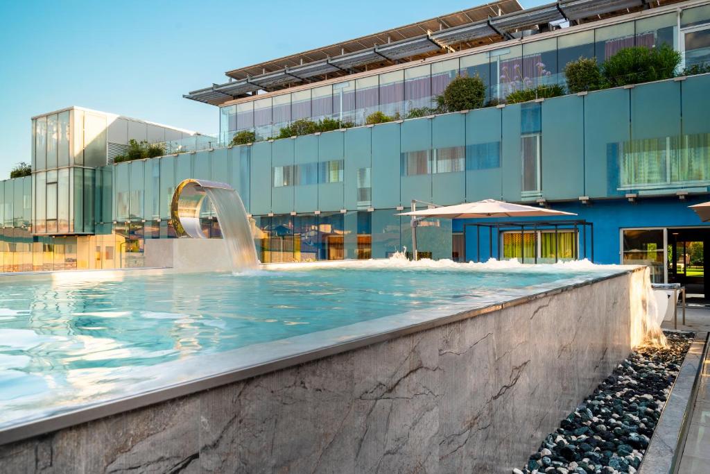 ein Schwimmbad mit Springbrunnen vor einem Gebäude in der Unterkunft San Ranieri Hotel - Meetings & Pool in Pisa