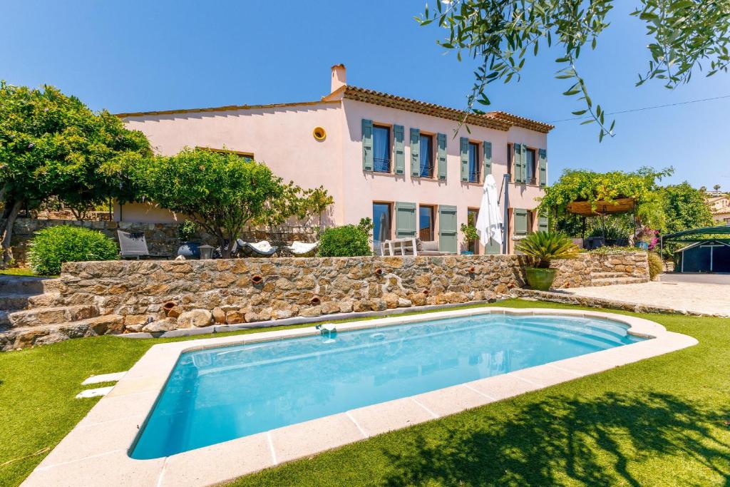 a villa with a swimming pool in front of a house at Villa Flore - Panoramic Sea View by Halldis in Vallauris