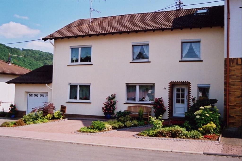 ein weißes Haus mit Fenstern und einer Auffahrt in der Unterkunft Ferienwohnung Steinebach in Daun