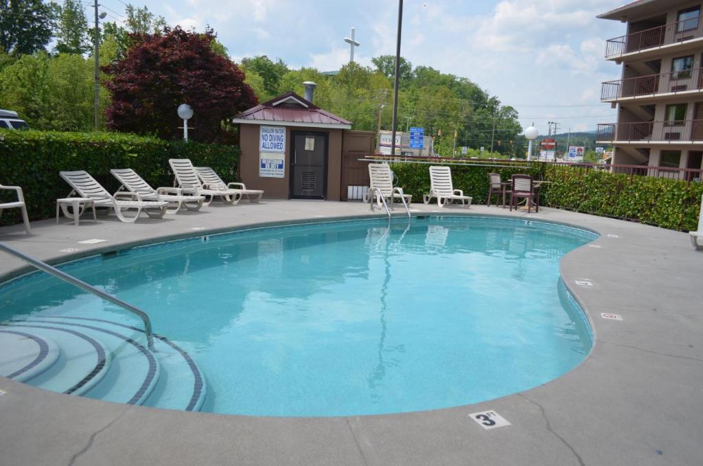 a large swimming pool with chairs and a building at Baymont by Wyndham Pigeon Forge near Island Drive in Pigeon Forge