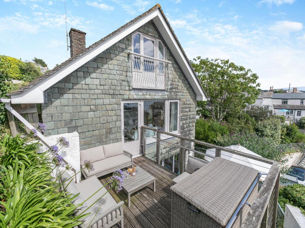 a house with a balcony with a table and chairs at Dolphins Reach in Saint Mawes