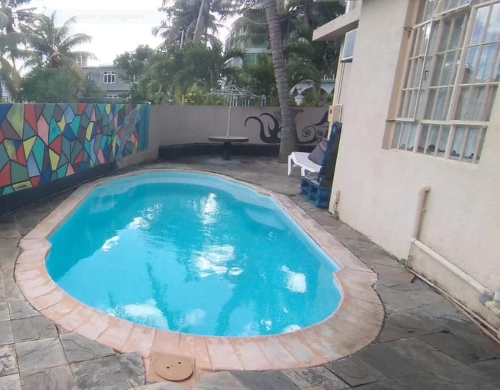 a swimming pool in front of a house at Family apartment with pool in Trou-aux-Biches, 80 m² in Trou aux Biches