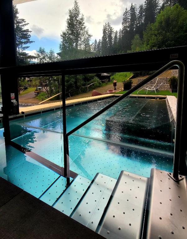 a view of a swimming pool through a window at Hotel Dahu in Madonna di Campiglio