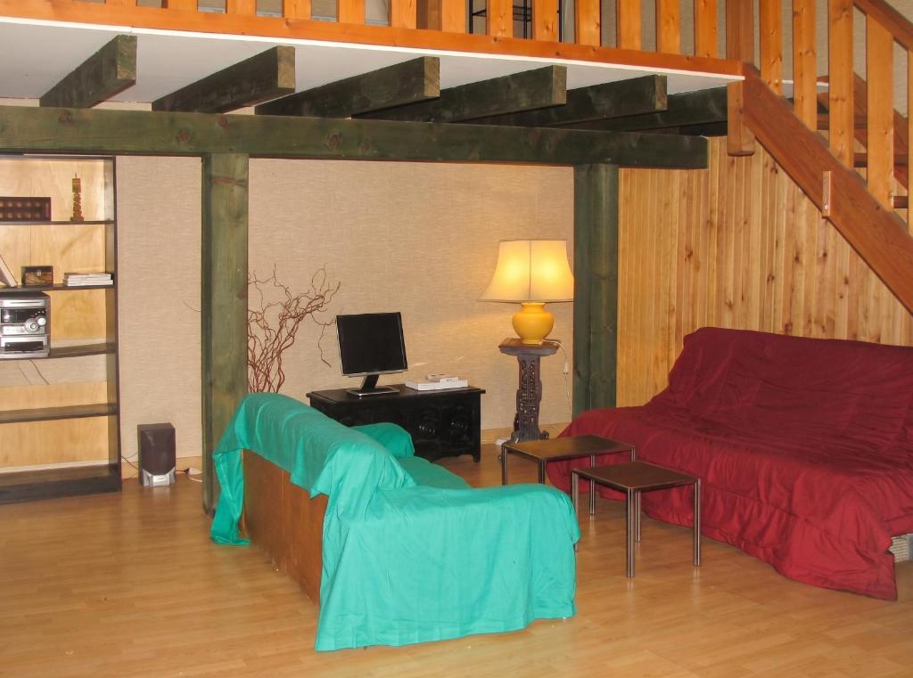 a living room with a couch and a bed at Studio confortable près de Beaumont-du-Périgord, 60 m², cheminée in Beaumont-du-Périgord