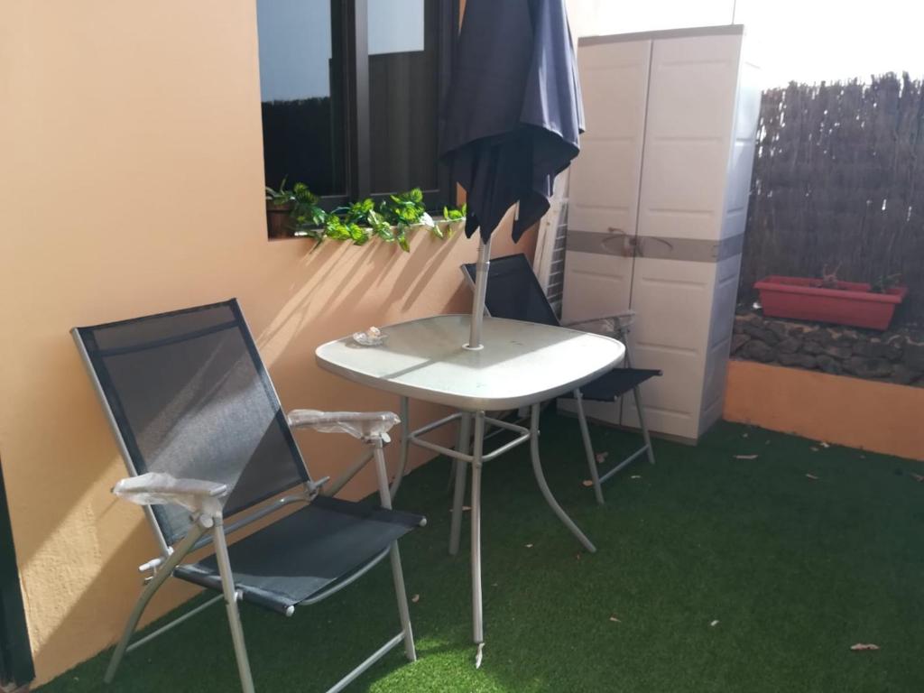 a table and two chairs and an umbrella at Charming Apartment La Oliva 30 sqm + Terrace in La Oliva