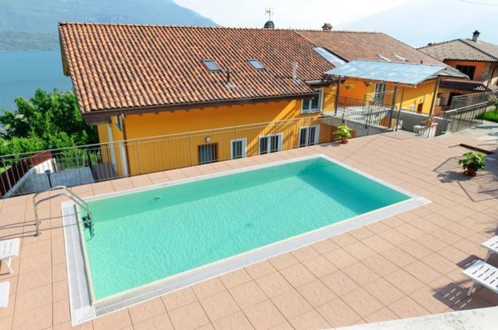 a house with a swimming pool in front of a house at Cozy apartment with lake view in Vercana