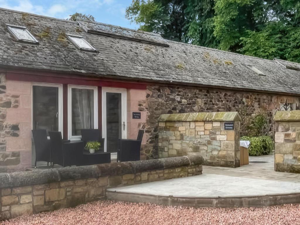 a stone cottage with a patio in front of it at Stewards Bothy - Uk48303 in Berwick-Upon-Tweed