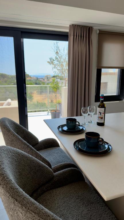 a dining table with two glasses and a bottle of wine at CasaMare Lagonisi Athens Riviera Luxury modern villas apartment's in Lagonissi