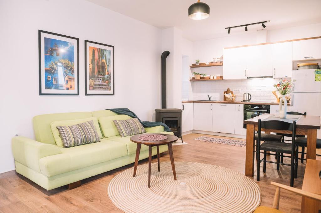 a living room with a green couch and a kitchen at Casa Hollaj in Vladimir