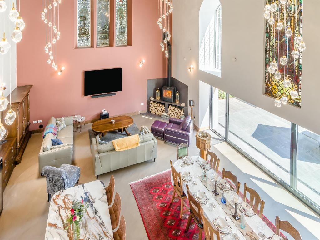 a living room with tables and chairs and a tv at Auld Kirk House in Duns
