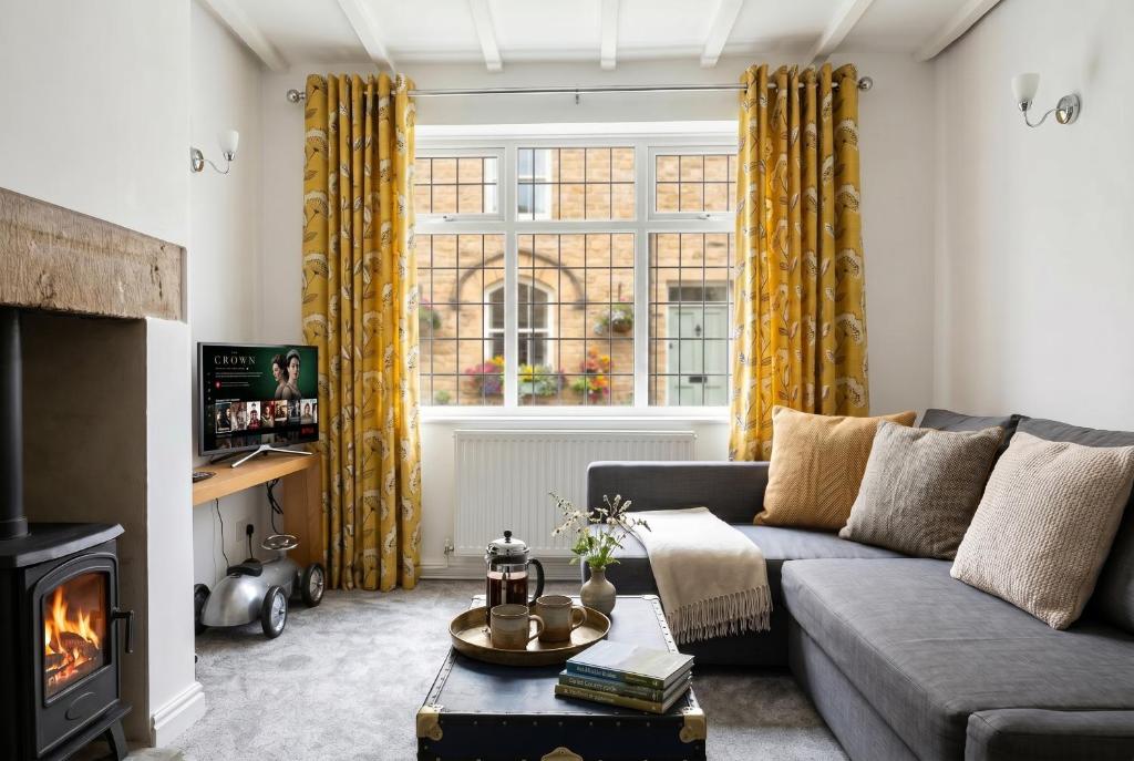 a living room with a couch and a fireplace at Willow Cottage in Pateley Bridge