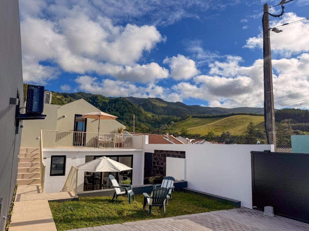 a house with chairs and a patio with mountains in the background at Terra Vivaz - Porto Bay Formosa in Porto Formoso