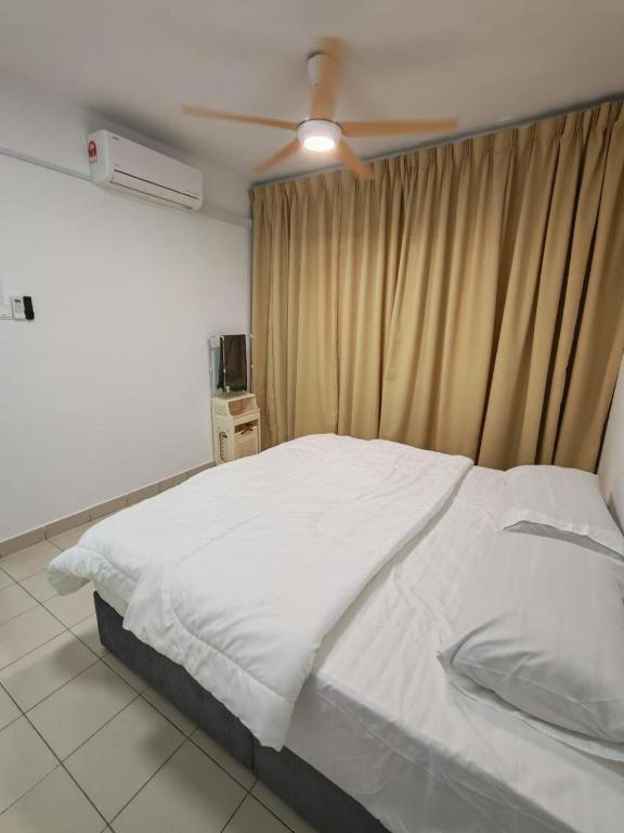 a bedroom with a white bed with a ceiling fan at Condo Apartment RSS in Malacca