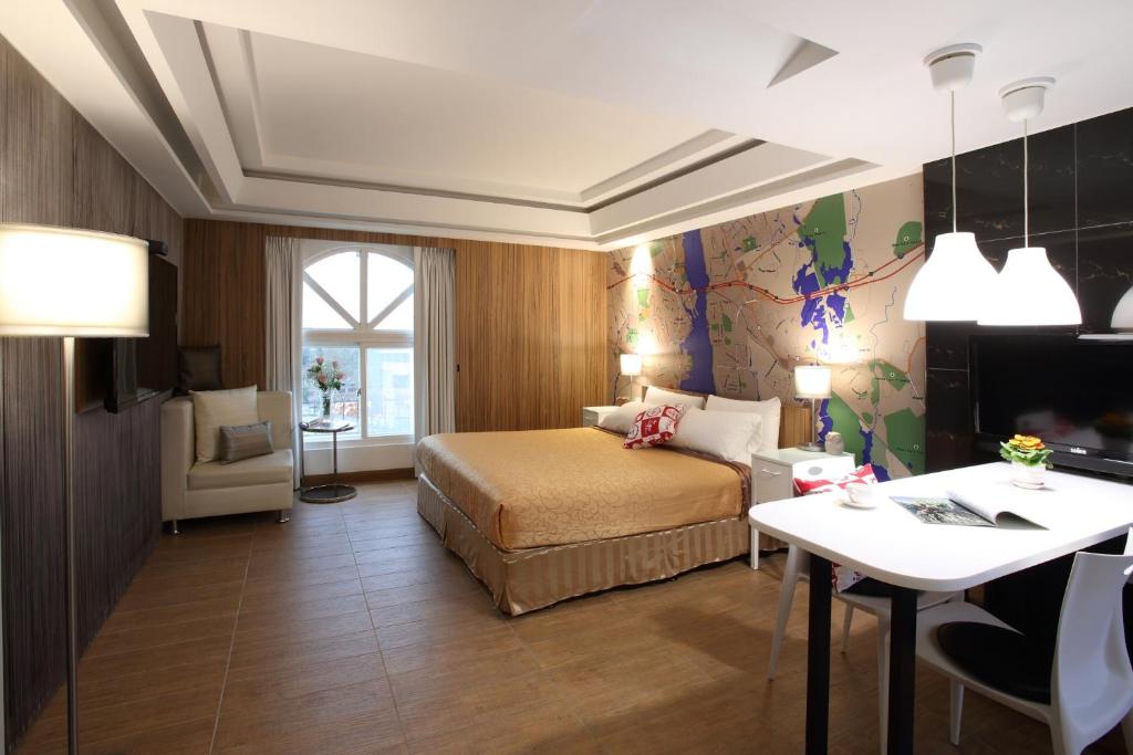 een hotelkamer met een bed en een bureau bij Long View Hotel in Tamsui