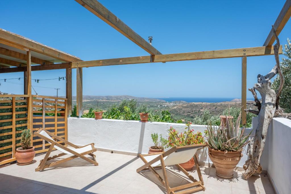 a patio with two chairs and potted plants at Lydia Guest House in Palekastron