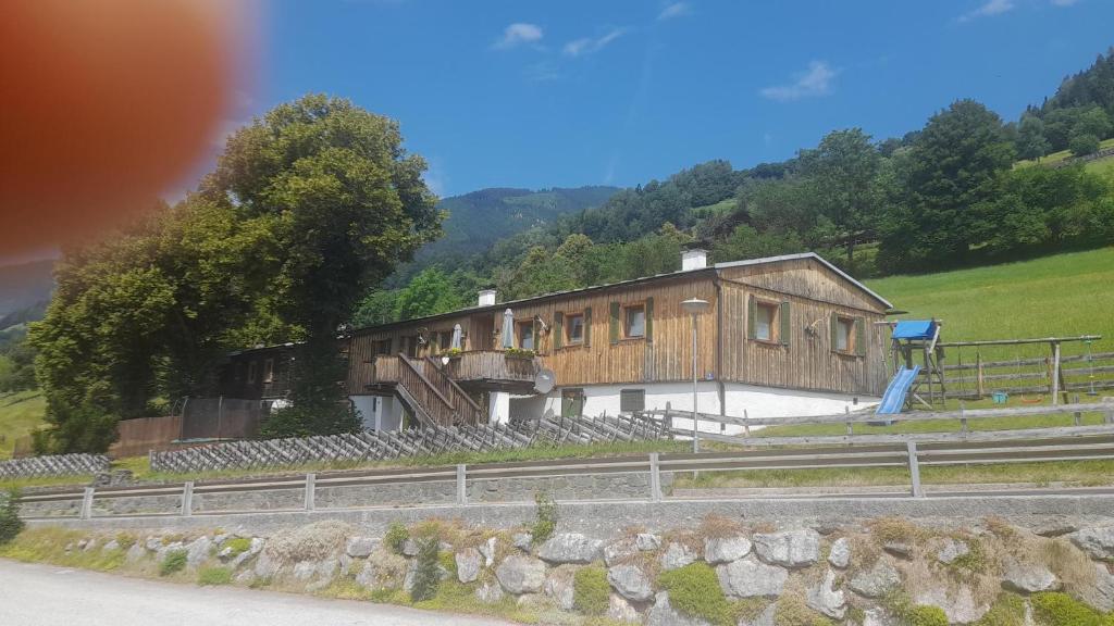 ein Holzhaus am Straßenrand in der Unterkunft Jägerchalet in Uttendorf