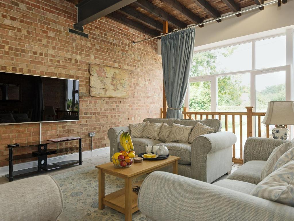 a living room with two couches and a brick wall at Church View - Ukc2302 in Wainfleet All Saints