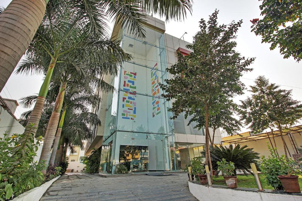 un edificio con palmeras delante en Hotel Sai Miracle, en Shirdi