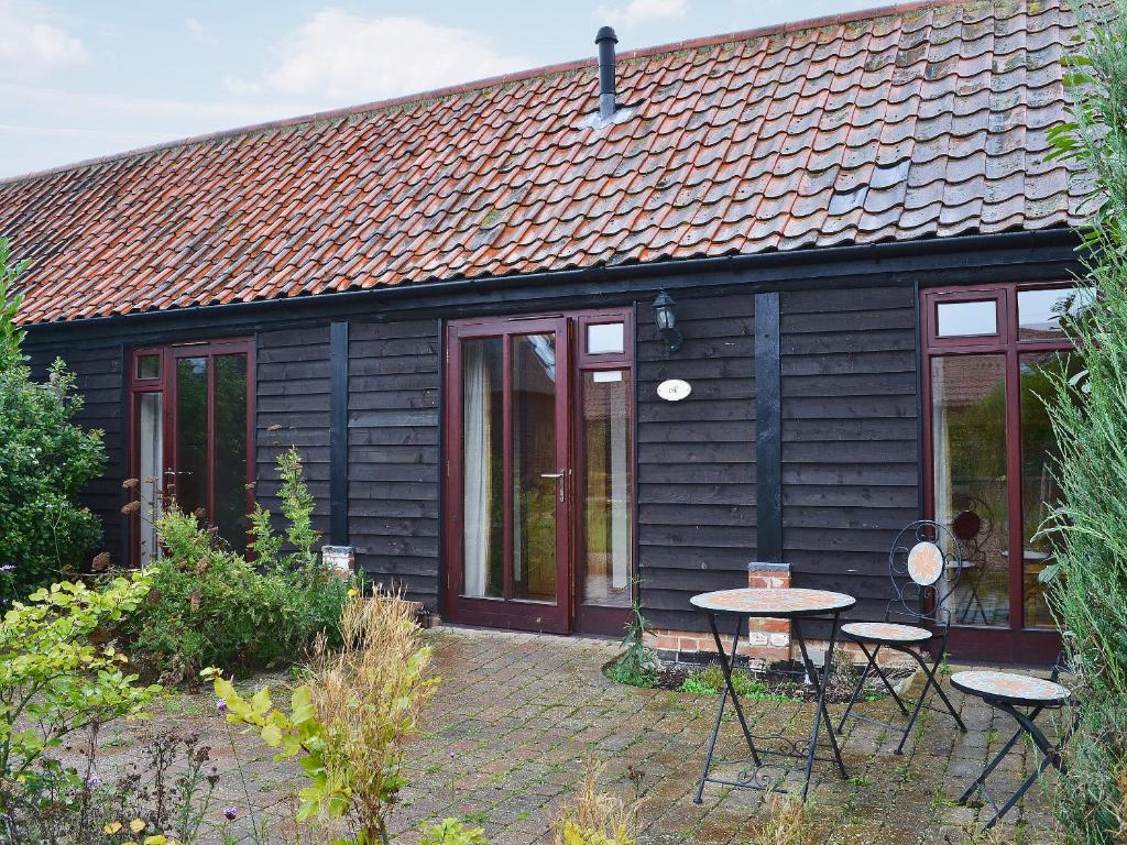 a black house with tables and chairs in front of it at Dill - E4324A in Catfield