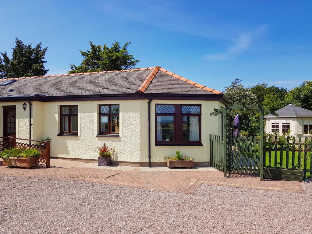 a small house with a gate and a fence at Trebor Cottage in Annan