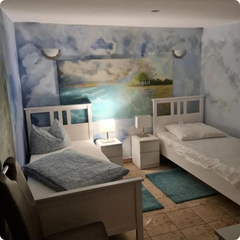 a bedroom with two beds and a painting on the wall at Fewo-Am-alten-Bahnhof in Tangerhütte