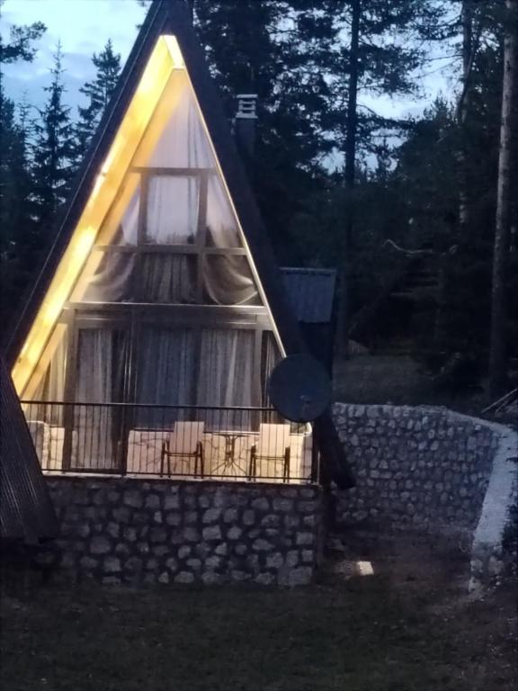 a cabin with a thatched roof with a window at Villa Moonlight,Žabljak in Žabljak