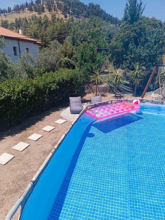 a blue swimming pool with a pink and white poolvisor at Edem House - Volos Greece in Volos