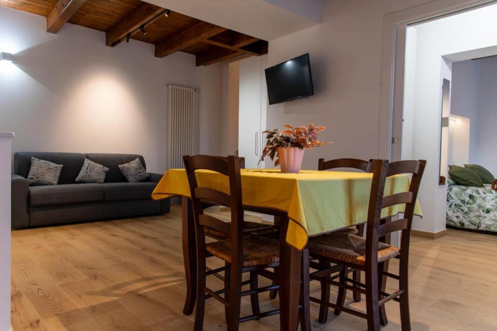 a dining room with a yellow table and chairs at La Stella del Borgo in Castelmezzano