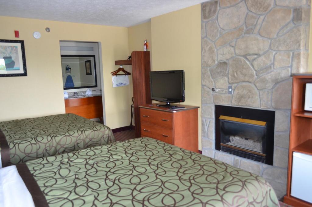 a hotel room with a bed and a fireplace at Baymont by Wyndham Pigeon Forge near Island Drive in Pigeon Forge