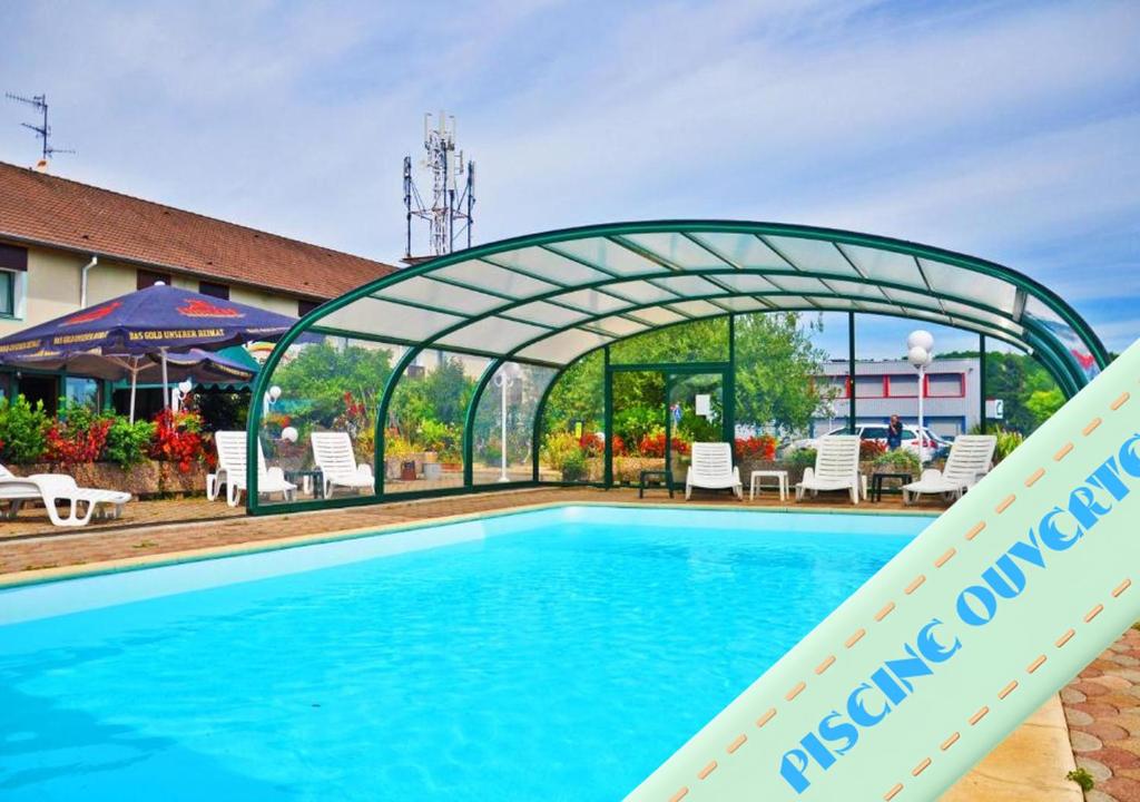 a swimming pool at a hotel with a metal arch over it at Contact Hôtel Arc-En-Ciel - Rénové in Mulhouse