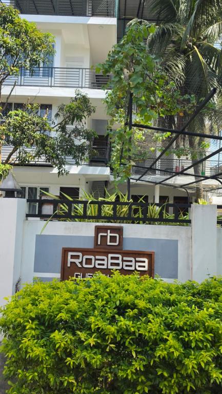 a sign in front of a white building at RoaBaa Guesthouse in Batticaloa