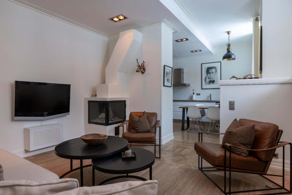a living room with a couch and chairs and a tv at Central Stylish Retreat with Sauna in Åre