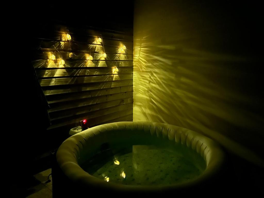 a dark bathroom with a tub in the dark at Maison tout confort in Corbie