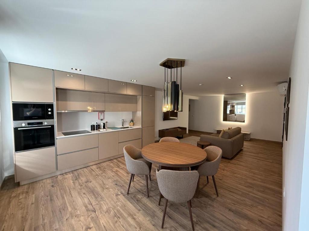 a kitchen and living room with a table and chairs at Apartamento do Teatro in Lamego