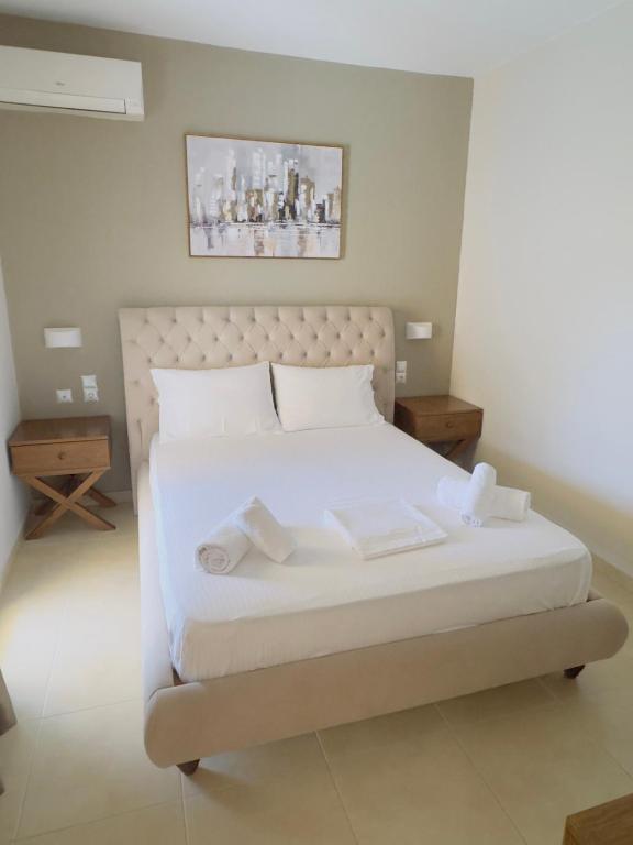 a bed with white sheets and pillows in a room at K & A Studios 1 in Nydri