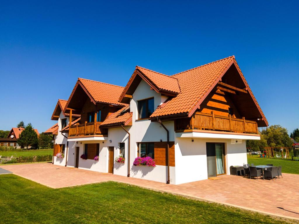 a house with a red roof at Blisko Natury Jacuzzi & Sauna in Pisz