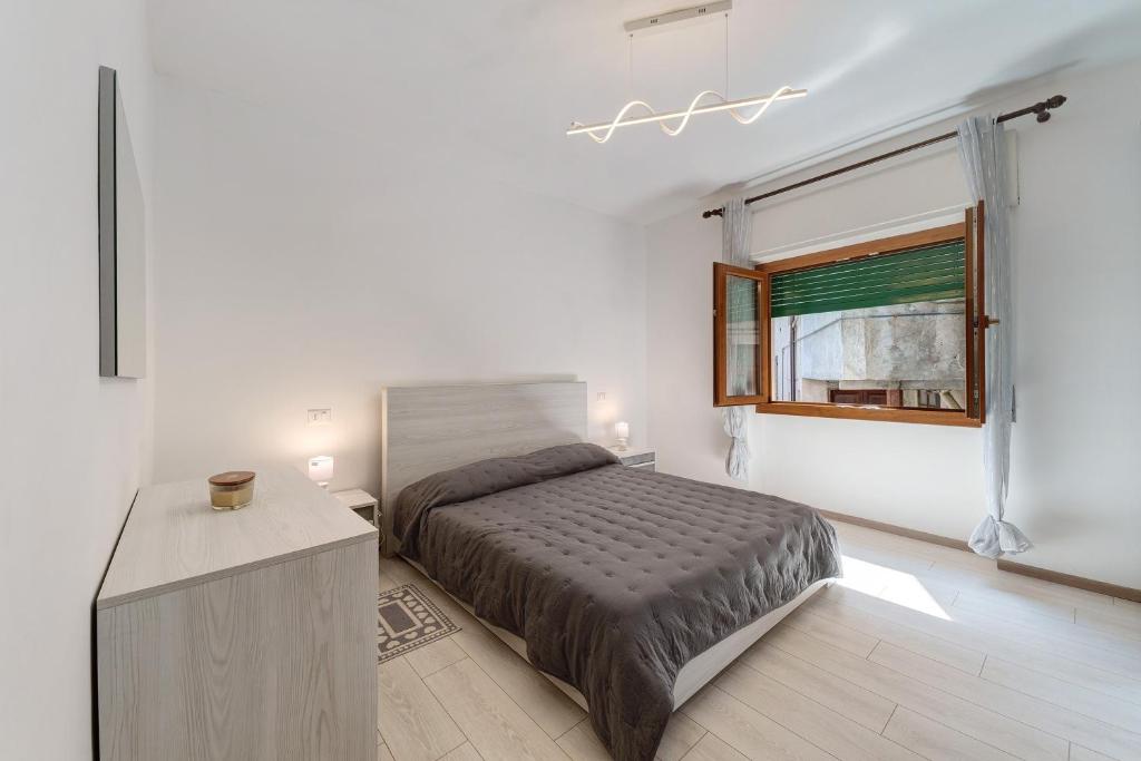 a white bedroom with a bed and a window at Casa Margherita in Forno