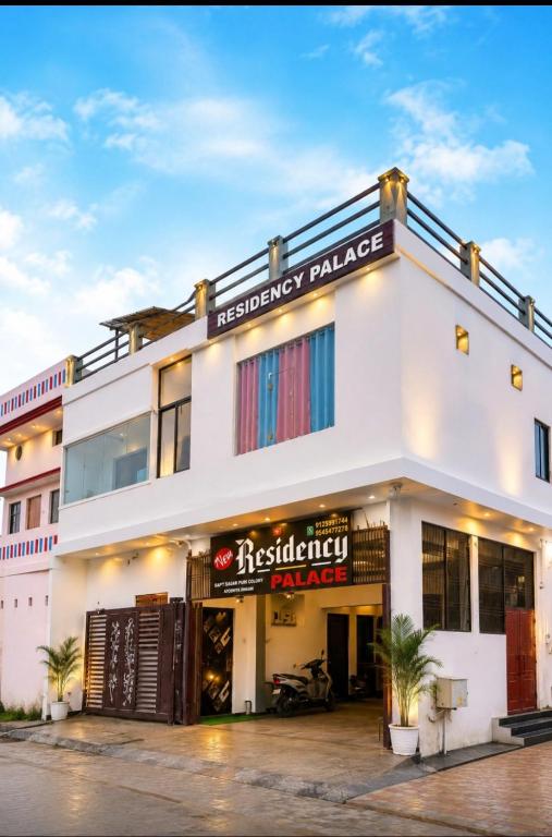 a facade of a white building with a restaurant at Hotel New Residency Ayodhya in Ayodhya