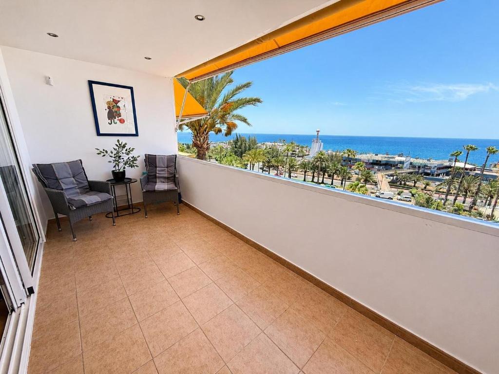 a room with a balcony with a view of the ocean at Top augestattetes Apartment Monte Rojo in Maspalomas
