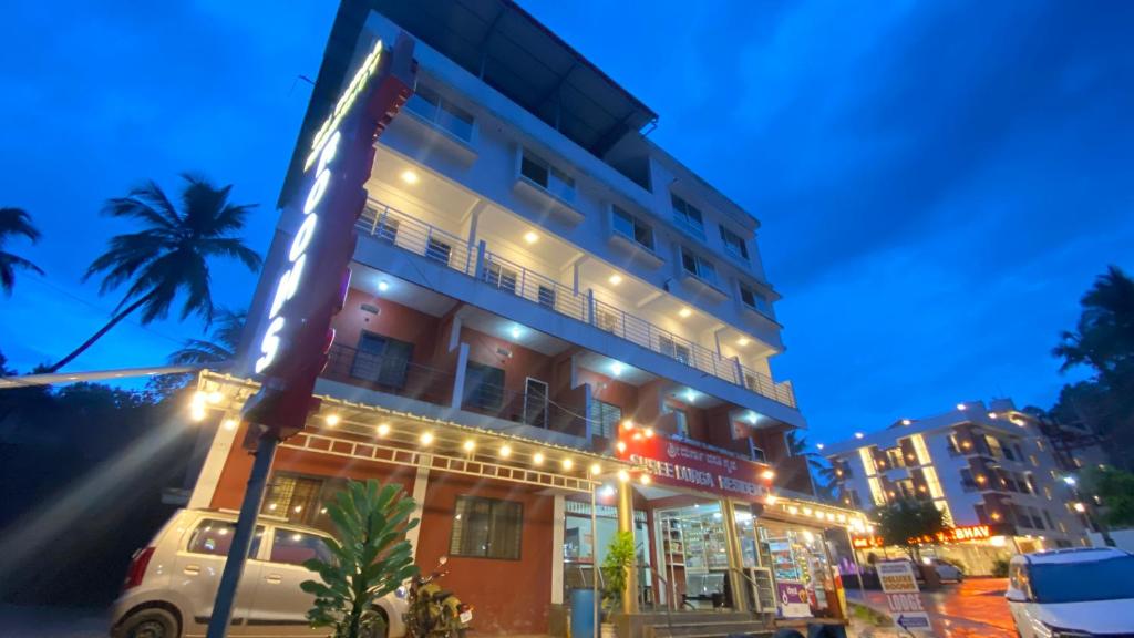 a building with a sign on a street at night at Sri Durga Residency in Subrahmanya