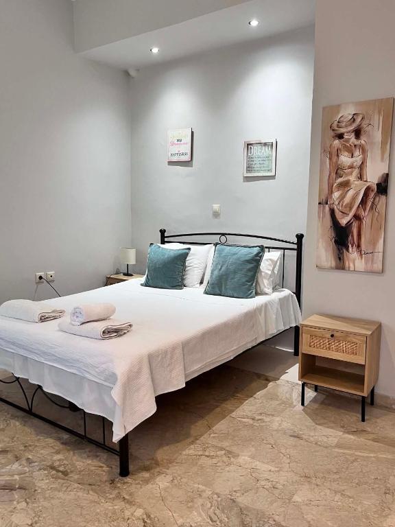 a bedroom with a large bed with blue pillows at Studios Μιχαλαρεα in Kyparissia