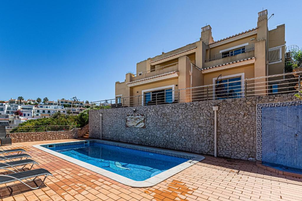 a villa with a swimming pool in front of a house at Villa Sea View Carvoeiro in Carvoeiro