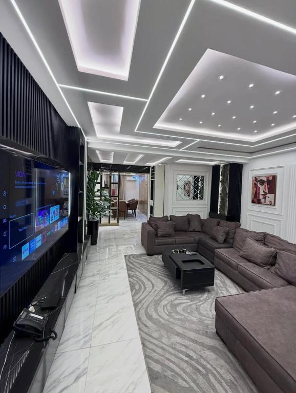 a living room with a couch and a tv at De Lexury Homes in Otinshi