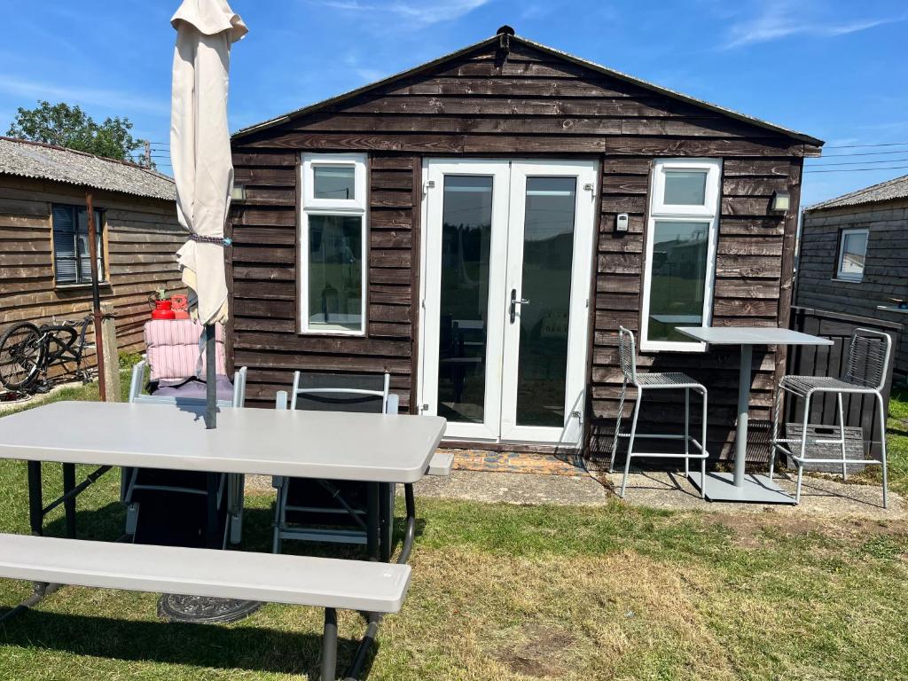 a cabin with a table and chairs in the yard at The Lookout in Leysdown-on-Sea