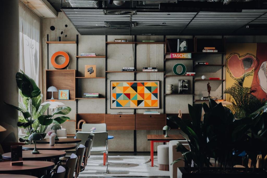 a restaurant with tables and chairs and a painting on the wall at URBAN LOFT Cologne in Cologne