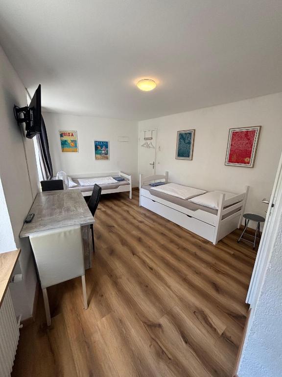 a large room with two beds and a desk at Haus zur Eiche Private 1 Zimmerstudios in Chur