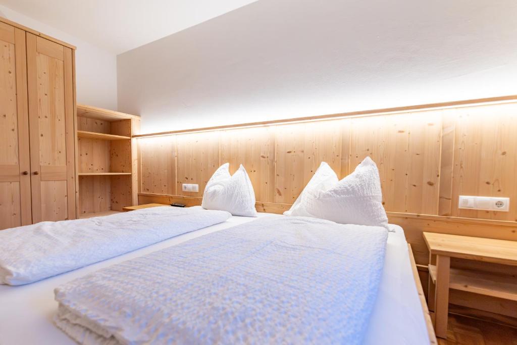 a bedroom with a large bed with white pillows at Gasthof Anich in Natz-Schabs