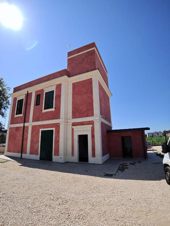 a red and white building with a car parked in front at Tenuta MAREALE in Anzio