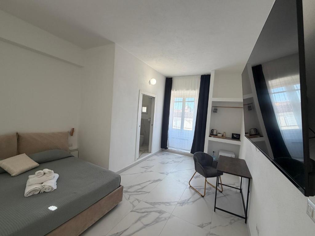 a bedroom with a bed and a table and a chair at Alexandra Rooms & Suitess in Sassari