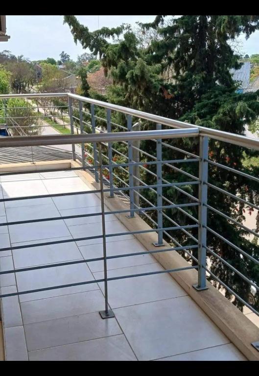a metal railing on a balcony with trees in the background at Departamentos Maxx II in Colón